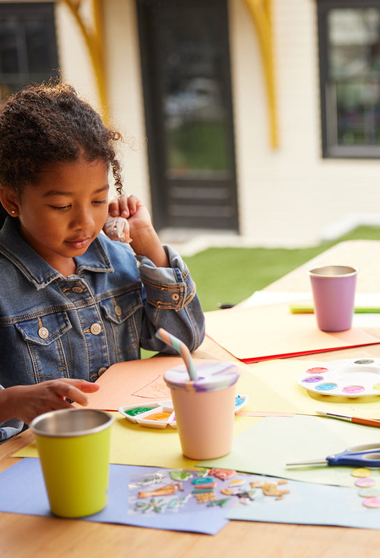 Kids painting with sippy cups on table