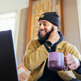 Guy with purple coffee mug and laptop inside