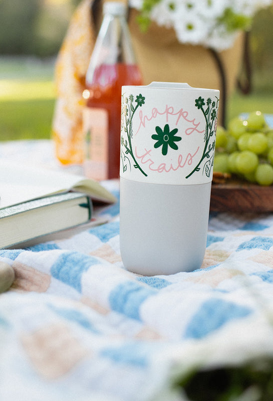 Anna Vaus 'Happy Trails' 16oz Tumbler on blanket at picnic