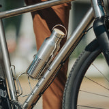 Silver water bottle in bicycle water bottle cage.
