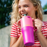 Teenager drinking from a pink tumbler with