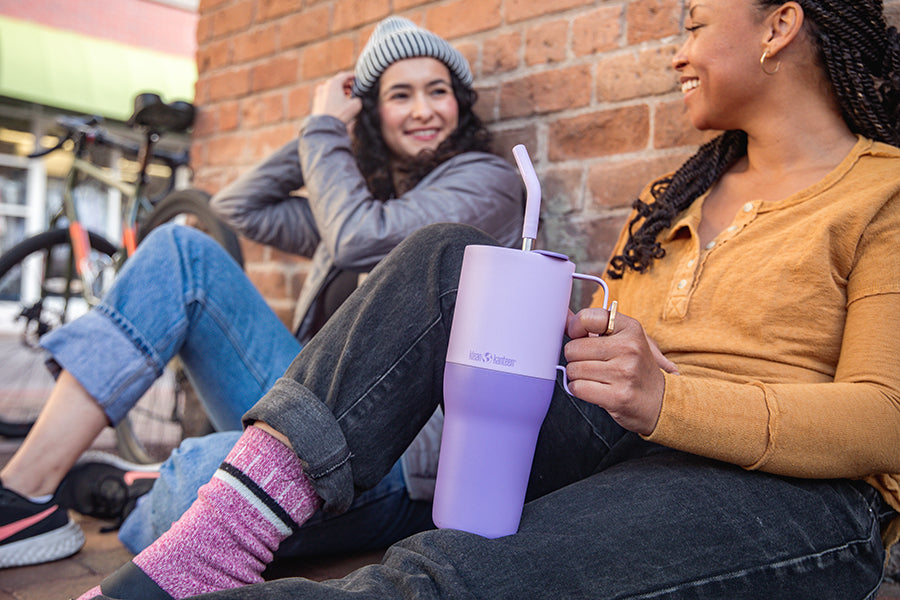 Women chatting with tumbler cup in hand