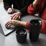 Man and woman on laptop with coffee tumblers