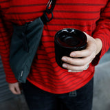 Person holding black tumbler in hand