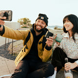 Couple taking selfie with tumblers and wine