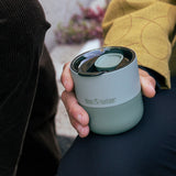 Person holding a Klean Kanteen insulated cup outdoors