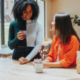 Two women at coffee shop with tumblers