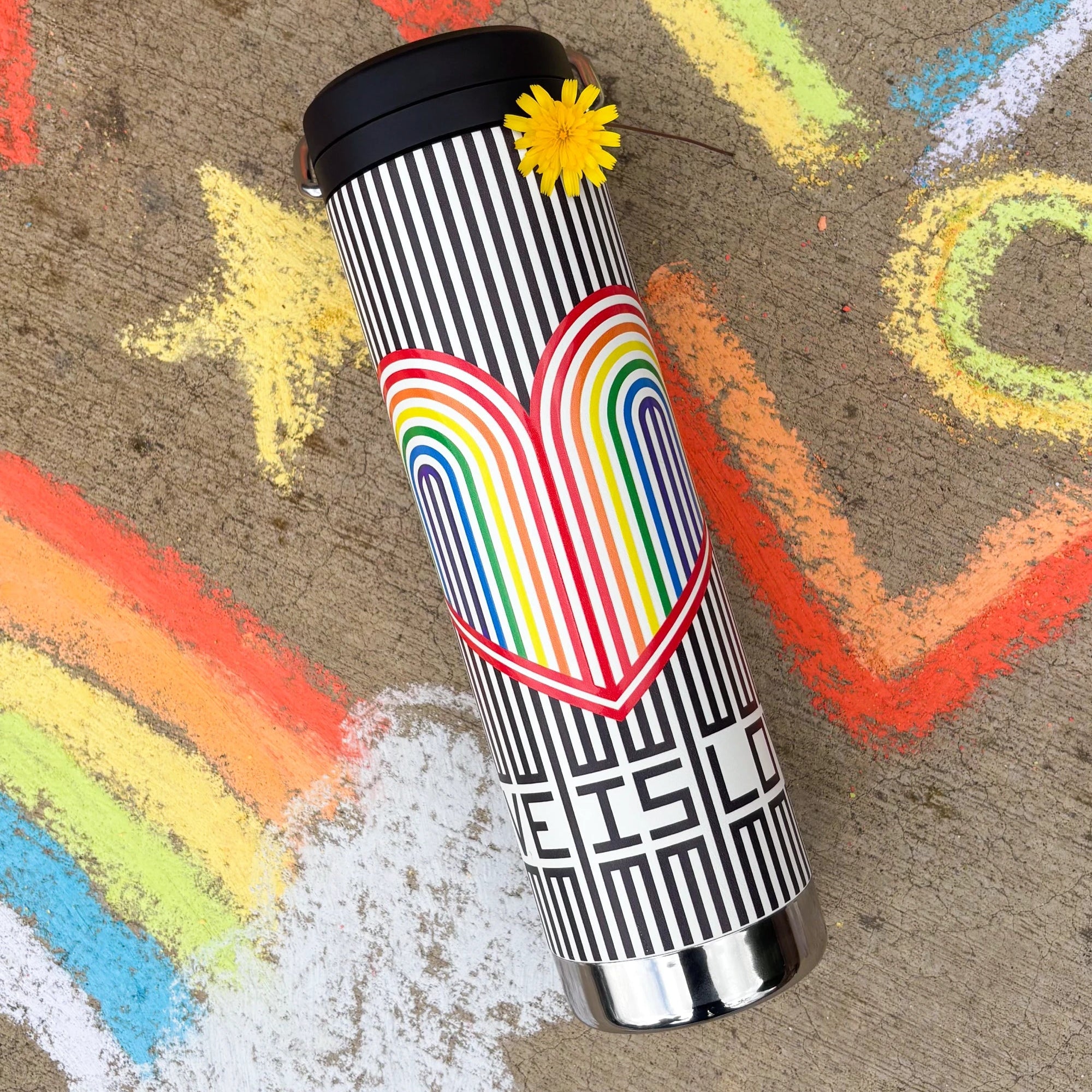 Water bottle with rainbow and heart design on a surface with chalk drawings