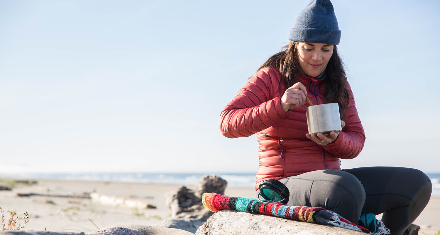 Girl eating soup on on beach in food container