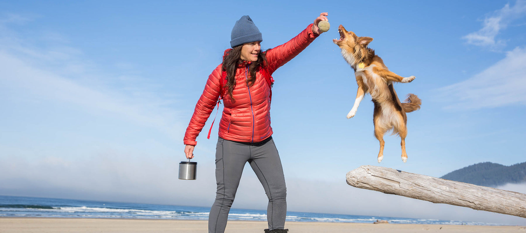 Woman on beach with dog and food canister
