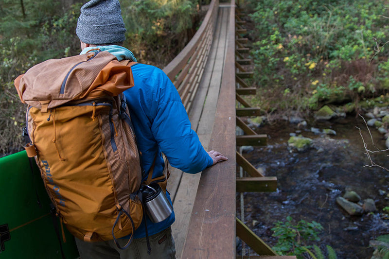 Hiker on bridge with food canister