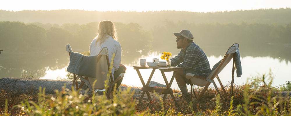 Couple sitting having picnic by lake