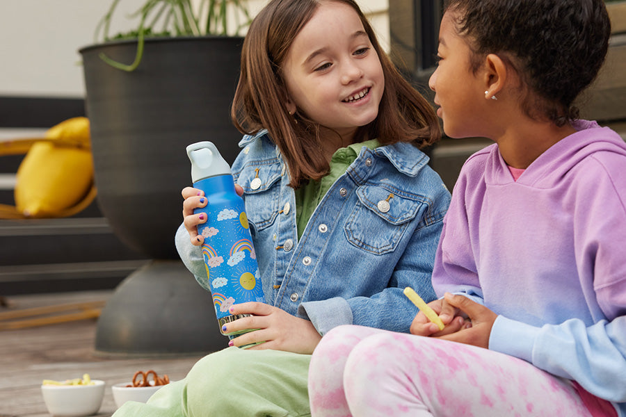 Girls on steps chatting, with water bottle in hand