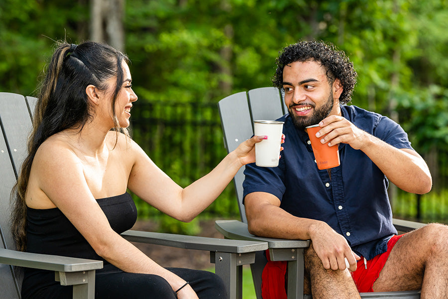Couple in chairs drinking from steel pints