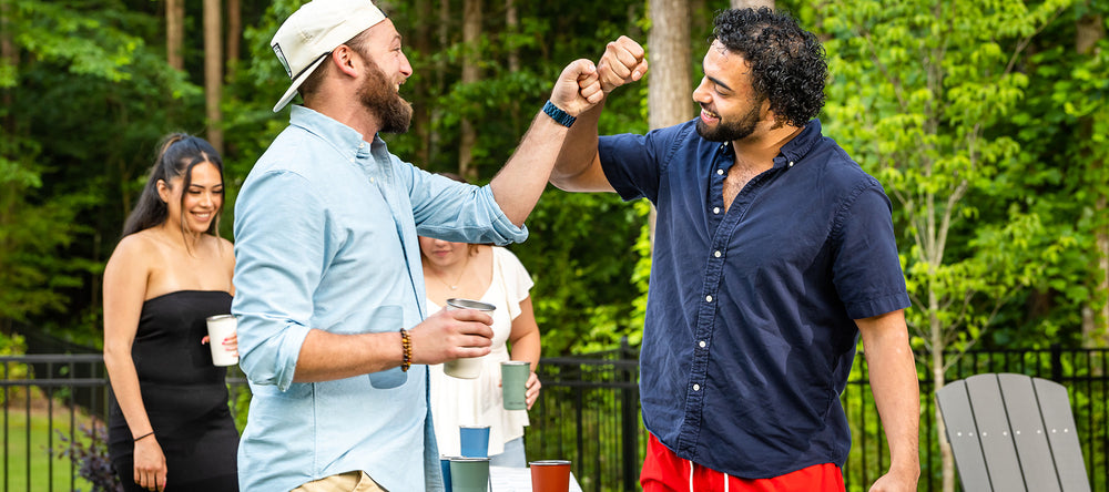 Guys playing beer pong and fist bumping
