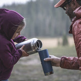Man and child refilling water bottles outside