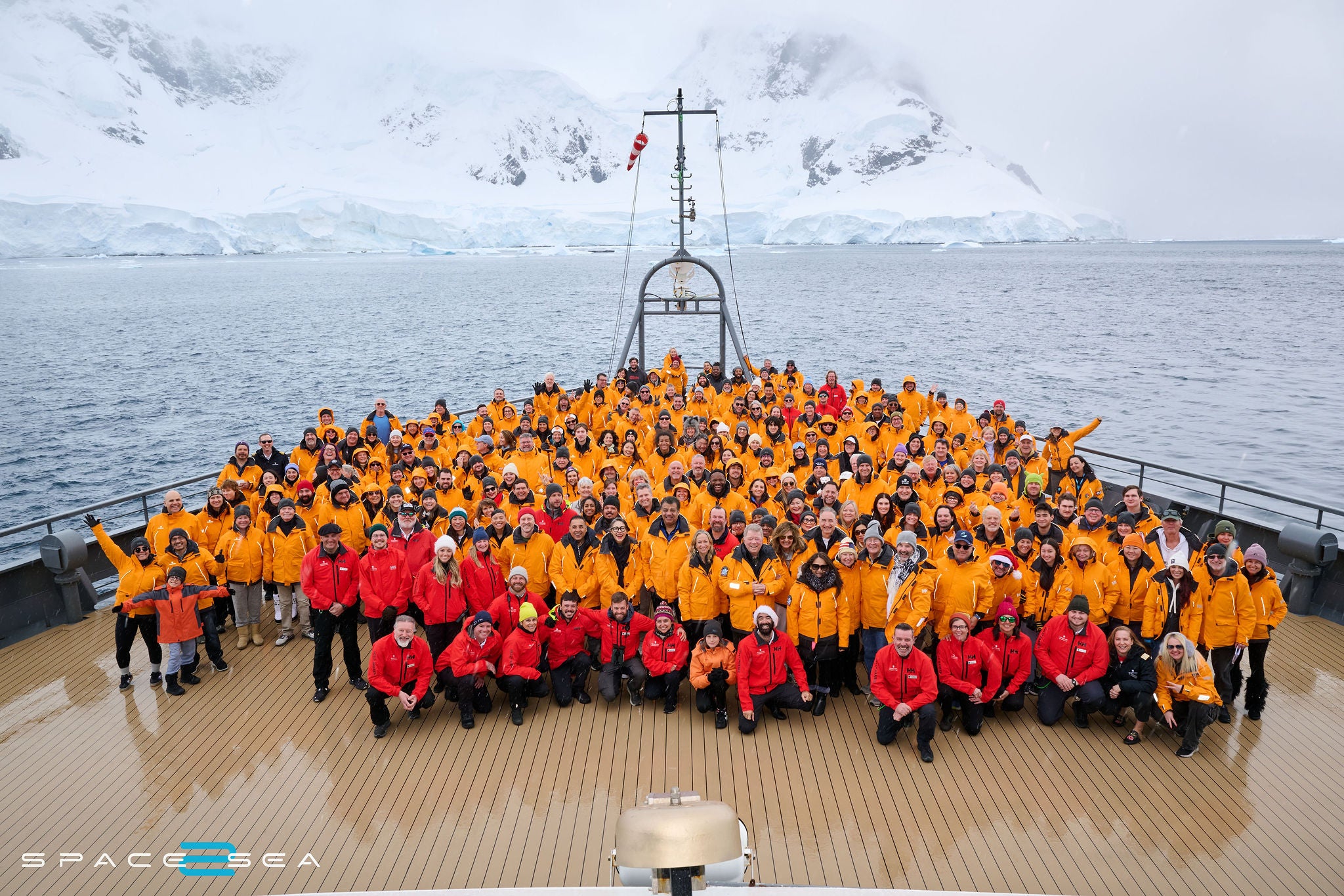 A group of people in bright jackets on a ship in Antarctica.