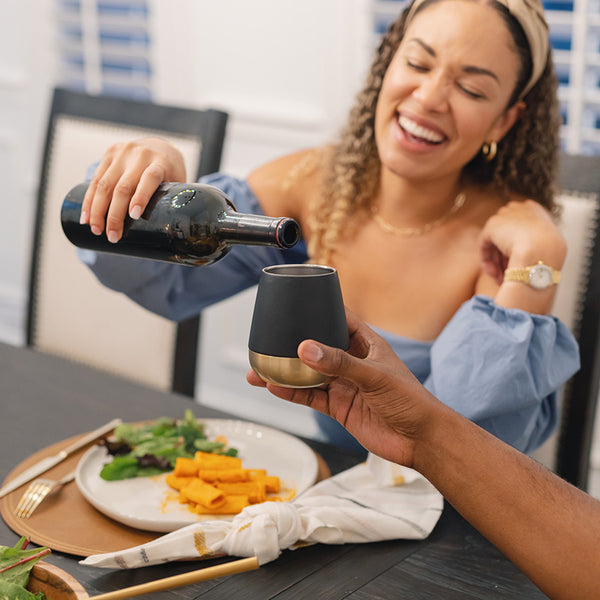 https://www.kleankanteen.com/cdn/shop/files/10oz_Rise_Wine_Tumbler_BlackGold_woman_dinner_square_600x.jpg?v=1693499236