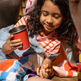 Girl drinking from steel cup with snacks