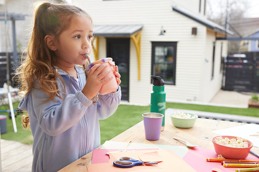 Girl drinking from sippy cup with straw