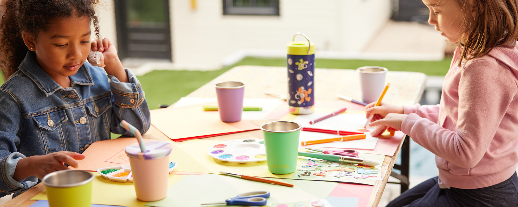 Kids painting with sippy cups on table