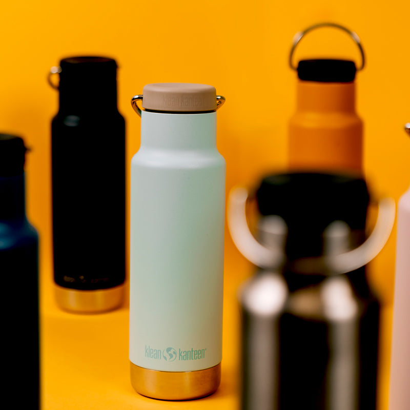 Light blue insulated bottle with cap on a yellow background
