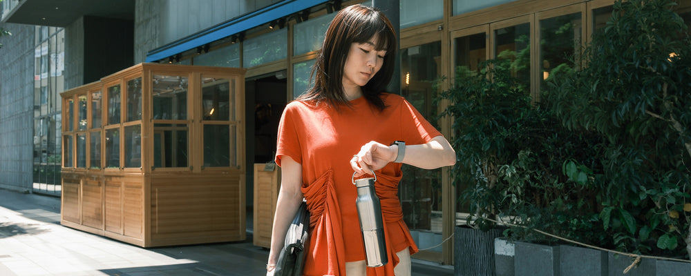 Office woman with Reflect water bottle in city