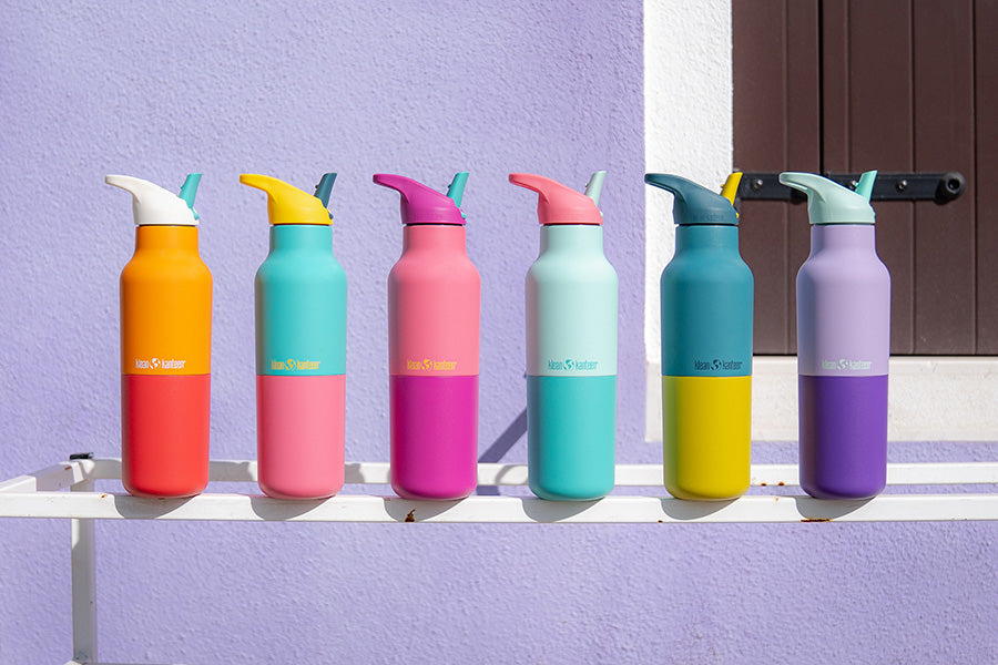 Set of colorful water bottles on a window ledge