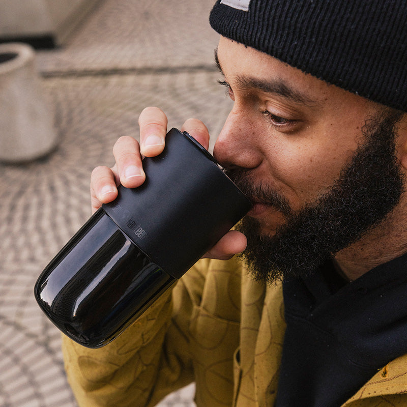 Guy drinking from black tumbler