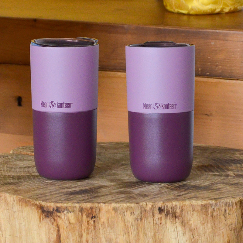 Two purple tumblers on wood stump tableindoors