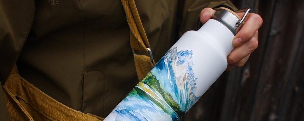 Earth day bottle with mountain graphic - pulling out of purse
