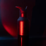 Red metallic water bottle with a dark background