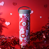 Tumbler with pink and red pattern on a red background with heart shapes
