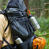Person with a backpack and hiking gear with 64oz Wide water bottle