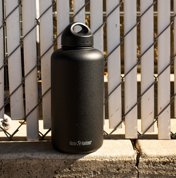 Black water bottle against fence