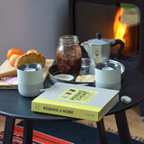 Two tumblers on table with food in front of fire