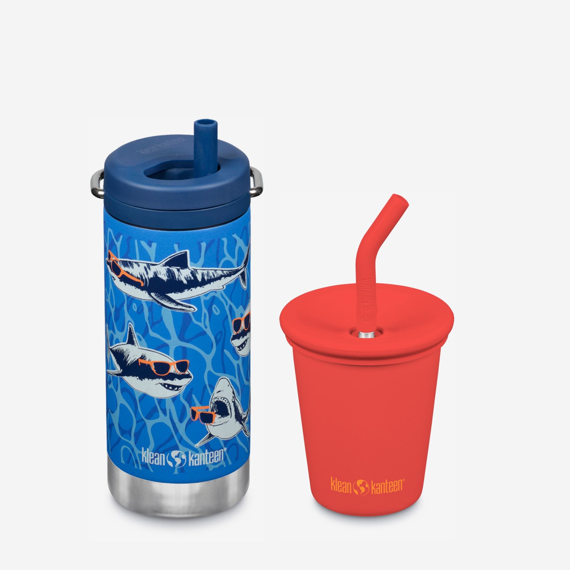 Blue tumbler with shark design and red cup with straw on a white background