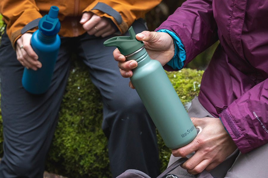 Woman flipping sport cap up to drink from water bottle