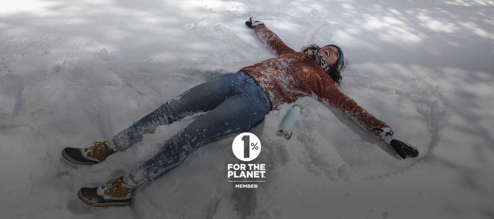 Woman making snow angels with water bottle