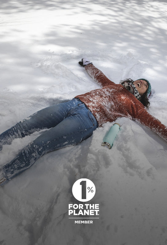 Woman making snow angels with water bottle
