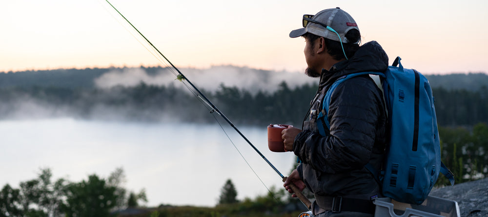 Guy fishing with coffee mug