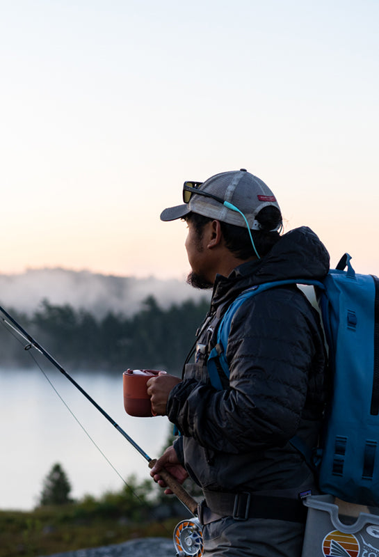 Guy fishing with coffee mug