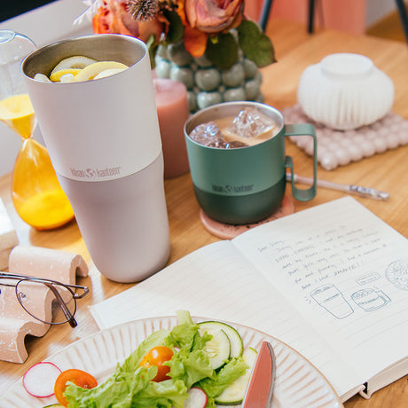 Rise Tumblers on table with book and food