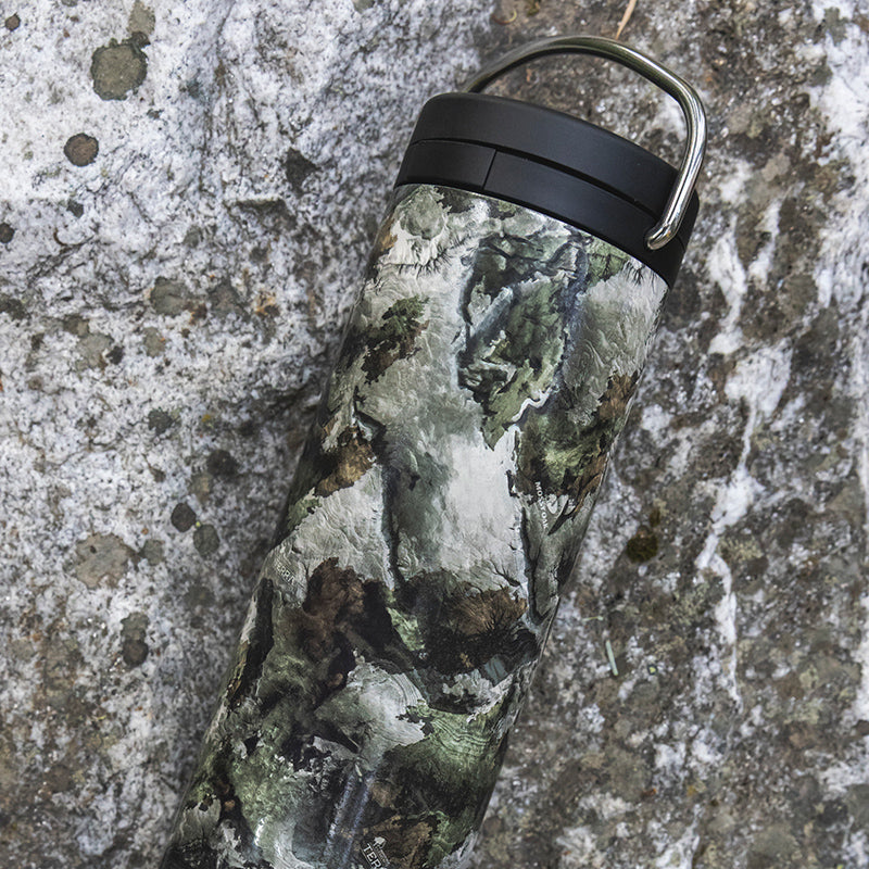 Camoflauge bottle against rock