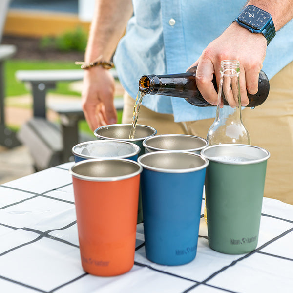 Pouring beer into steel pint cups for beer pong