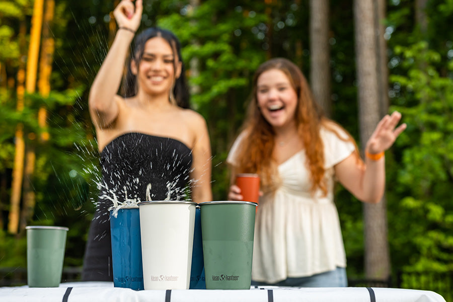 Girls playing beer pint with steel pints