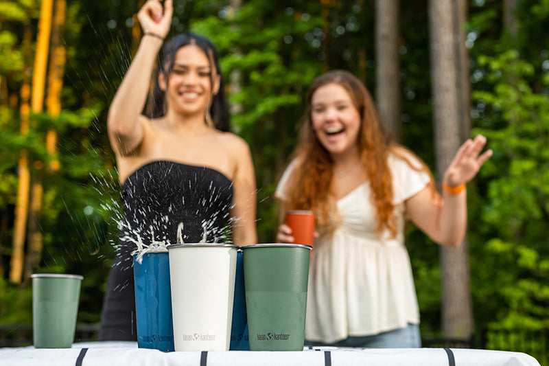 Girls playing beer pint with steel pints