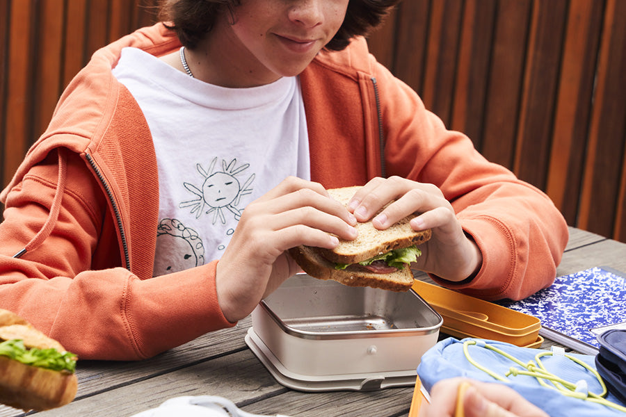 Kid at school with lunch and sandwich