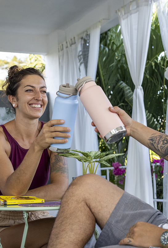 Couple smiling and traveling with water bottles